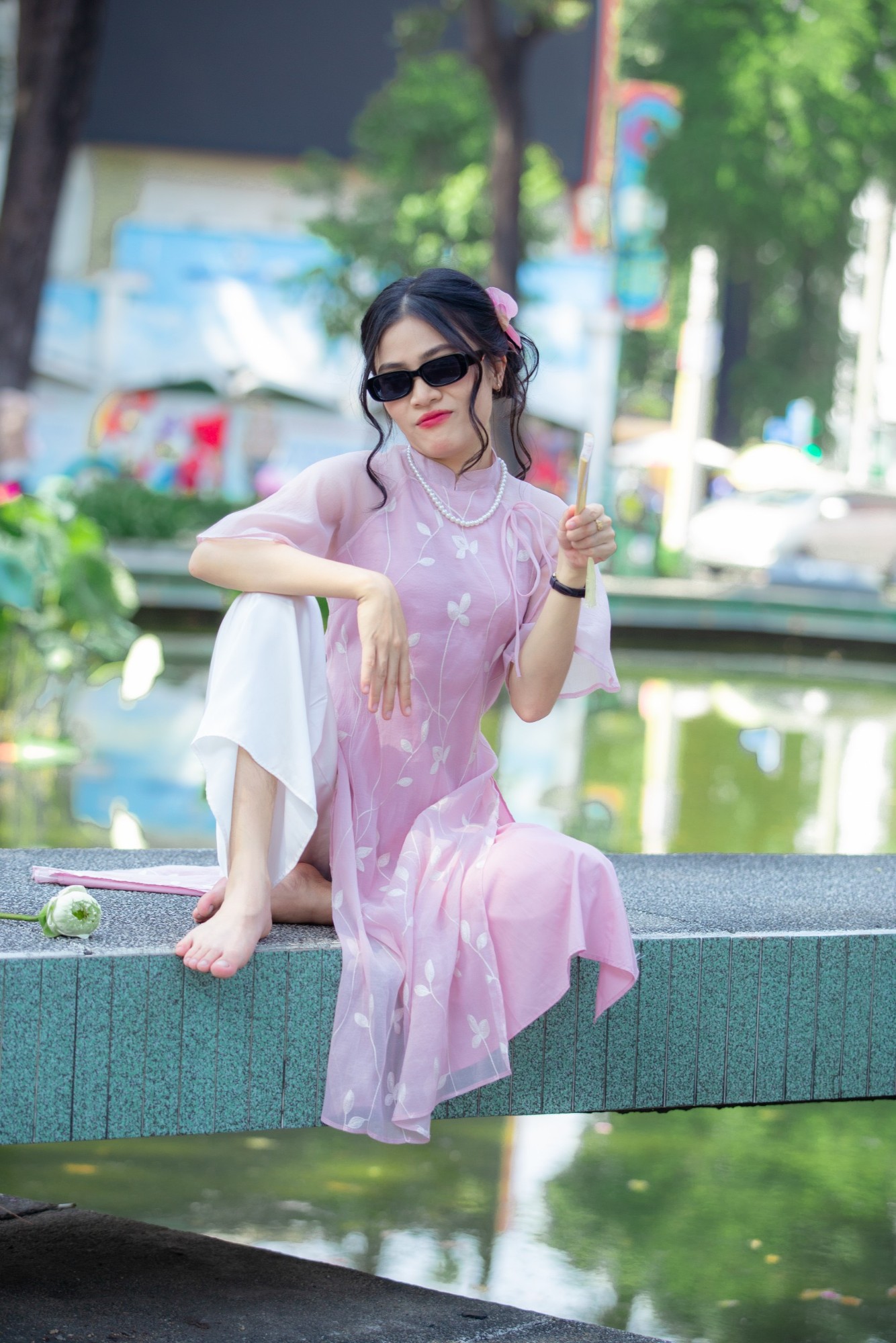 Áo dài hồng, kính râm, cầm quạt